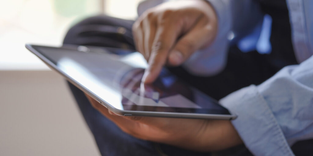 Man looking at brochures on ipad